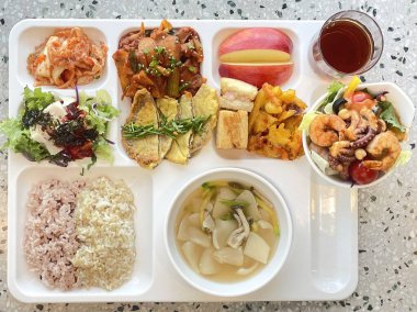 Masada kimçi, turşu sebze turşusu ve baharatlı sebzeler gibi çeşitli banchan (yan yemekler) içeren canlı bir Kore yemeği serpintisi. Yemek fotoğrafçılığı için mükemmel, geleneksel Korece sergileniyor..