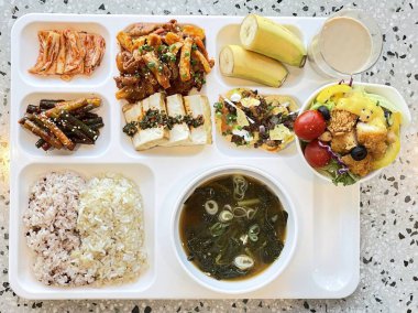 Masada kimçi, turşu sebze turşusu ve baharatlı sebzeler gibi çeşitli banchan (yan yemekler) içeren canlı bir Kore yemeği serpintisi. Yemek fotoğrafçılığı için mükemmel, geleneksel Korece sergileniyor..