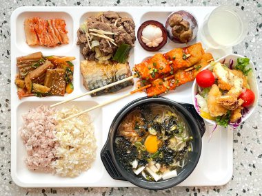 Masada kimçi, turşu sebze turşusu ve baharatlı sebzeler gibi çeşitli banchan (yan yemekler) içeren canlı bir Kore yemeği serpintisi. Yemek fotoğrafçılığı için mükemmel, geleneksel Korece sergileniyor..