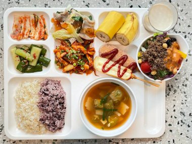 Masada kimçi, turşu sebze turşusu ve baharatlı sebzeler gibi çeşitli banchan (yan yemekler) içeren canlı bir Kore yemeği serpintisi. Yemek fotoğrafçılığı için mükemmel, geleneksel Korece sergileniyor..