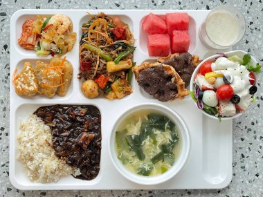 Masada kimçi, turşu sebze turşusu ve baharatlı sebzeler gibi çeşitli banchan (yan yemekler) içeren canlı bir Kore yemeği serpintisi. Yemek fotoğrafçılığı için mükemmel, geleneksel Korece sergileniyor..