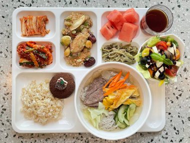 Masada kimçi, turşu sebze turşusu ve baharatlı sebzeler gibi çeşitli banchan (yan yemekler) içeren canlı bir Kore yemeği serpintisi. Yemek fotoğrafçılığı için mükemmel, geleneksel Korece sergileniyor..