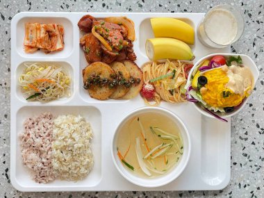 Masada kimçi, turşu sebze turşusu ve baharatlı sebzeler gibi çeşitli banchan (yan yemekler) içeren canlı bir Kore yemeği serpintisi. Yemek fotoğrafçılığı için mükemmel, geleneksel Korece sergileniyor..