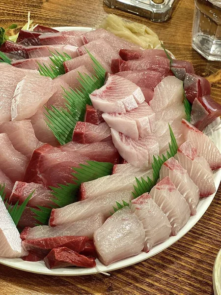 Taze ve narin sashimi dilimleri, canlı renkler ve mükemmel kesimlerle güzelce sunuluyor. Bu geleneksel Japon lezzeti kaliteli deniz ürünlerinin saf tatlarını vurgular..