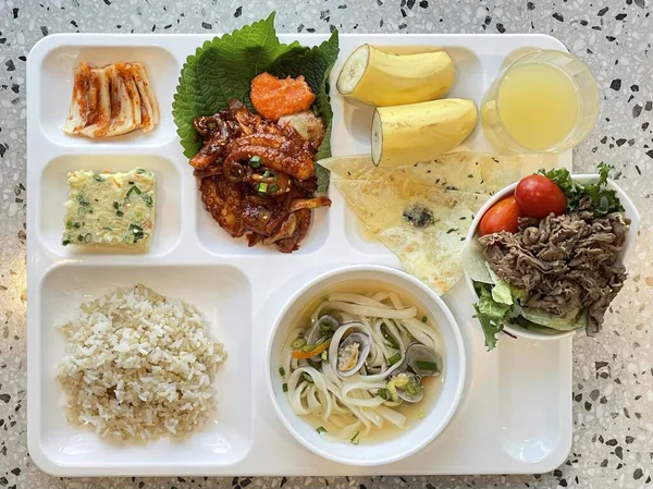 Masada kimçi, turşu sebze turşusu ve baharatlı sebzeler gibi çeşitli banchan (yan yemekler) içeren canlı bir Kore yemeği serpintisi. Yemek fotoğrafçılığı için mükemmel, geleneksel Korece sergileniyor..