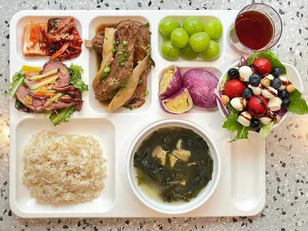 Masada kimçi, turşu sebze turşusu ve baharatlı sebzeler gibi çeşitli banchan (yan yemekler) içeren canlı bir Kore yemeği serpintisi. Yemek fotoğrafçılığı için mükemmel, geleneksel Korece sergileniyor..