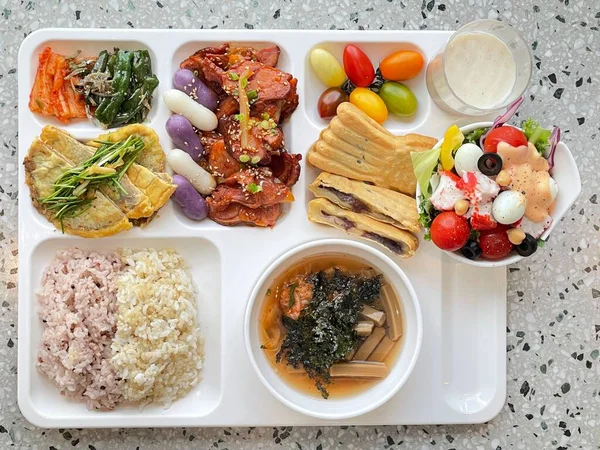 Masada kimçi, turşu sebze turşusu ve baharatlı sebzeler gibi çeşitli banchan (yan yemekler) içeren canlı bir Kore yemeği serpintisi. Yemek fotoğrafçılığı için mükemmel, geleneksel Korece sergileniyor..