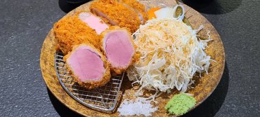 Çıtır tonkatsu, Japon usulü kızarmış domuz pirzolası dilimlenmiş lahana ve tuzlu sosla servis edilir. Lezzetli bir kıtır kıtır doku ve sulu et dengesi.