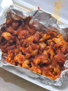 Baharatlı ve çiğnenmiş dakbal (Koreli tavuk ayağı) koyu, ateşli bir jöleyle kaplanmıştır. Yoğun sıcak ve tuzlu derinlikte lezzetli bir sokak yemeği favorisi. Maceracı yiyiciler için mükemmel..