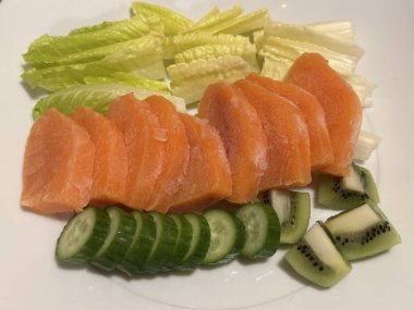 Taze salata taze yapraklı sebzeler, dilimlenmiş sebzeler ve rengarenk malzemelerin karışımı sağlıklı, canlı ve ferahlatıcı bir tat yaratmak için bir araya getirilmiş.