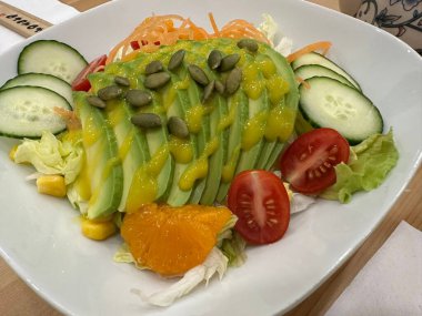 Taze salata taze yapraklı sebzeler, dilimlenmiş sebzeler ve rengarenk malzemelerin karışımı sağlıklı, canlı ve ferahlatıcı bir tat yaratmak için bir araya getirilmiş.