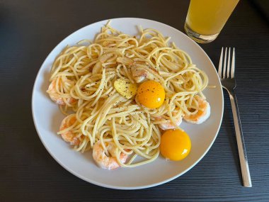Creamy spaghetti carbonara made with rich egg yolk sauce, crispy bacon, parmesan cheese, and freshly ground black pepper for a classic, indulgent Italian pasta dish.