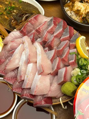 Taze ve narin sashimi dilimleri, canlı renkler ve mükemmel kesimlerle güzelce sunuluyor. Bu geleneksel Japon lezzeti kaliteli deniz ürünlerinin saf tatlarını vurgular..