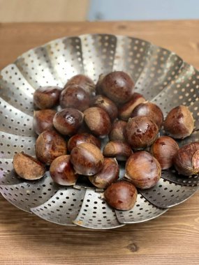 Parlak kahverengi kabuklu taze kestaneler, kızarmaya ya da pişirmeye hazır. Zengin, hafif tatlı aromalı mevsimlik bir favori, sıcak sonbahar yemekleri ve şenlikli ikramlar için mükemmel..