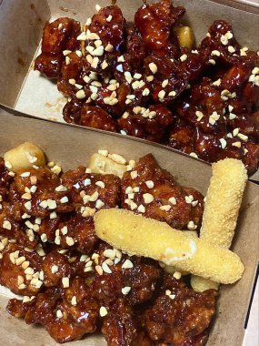 Kızarmış Kore tavuğu, tatlı ve baharatlı sosla mükemmel bir şekilde jölelenmiş. Yemek fotoğrafçılığı ve menüler için idealdir. Bu sevilen yemeğin dayanılmaz çıtırtısını ve lezzetini sergiler..