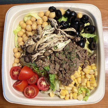 Taze salata taze yapraklı sebzeler, dilimlenmiş sebzeler ve rengarenk malzemelerin karışımı sağlıklı, canlı ve ferahlatıcı bir tat yaratmak için bir araya getirilmiş.