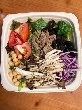 Taze salata taze yapraklı sebzeler, dilimlenmiş sebzeler ve rengarenk malzemelerin karışımı sağlıklı, canlı ve ferahlatıcı bir tat yaratmak için bir araya getirilmiş.