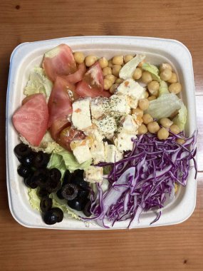 Taze salata taze yapraklı sebzeler, dilimlenmiş sebzeler ve rengarenk malzemelerin karışımı sağlıklı, canlı ve ferahlatıcı bir tat yaratmak için bir araya getirilmiş.