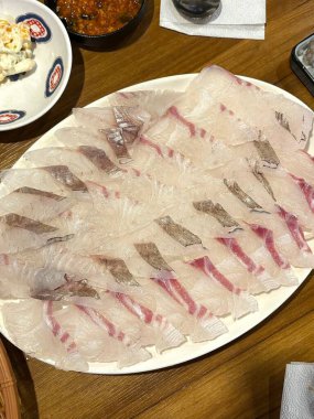 Taze ve narin sashimi dilimleri, canlı renkler ve mükemmel kesimlerle güzelce sunuluyor. Bu geleneksel Japon lezzeti kaliteli deniz ürünlerinin saf tatlarını vurgular..