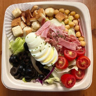 Taze salata taze yapraklı sebzeler, dilimlenmiş sebzeler ve rengarenk malzemelerin karışımı sağlıklı, canlı ve ferahlatıcı bir tat yaratmak için bir araya getirilmiş.