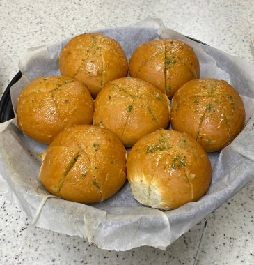 Kore sarımsaklı ekmeği, kremalı sarımsaklı tereyağı ve krem peynirle dolu yumuşak bir çörek, altın mükemmelliğinde pişirilmiş. Lezzetli ve biraz da tatlı. Zengin, aromatik bir tadı var..