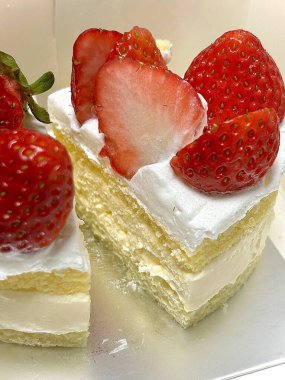 Strawberry cake with soft fluffy layers, topped with fresh strawberries and smooth cream, showcasing vibrant red fruit, delicate textures, and sweet inviting appearance in close-up detail