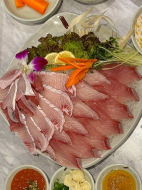 Taze ve narin sashimi dilimleri, canlı renkler ve mükemmel kesimlerle güzelce sunuluyor. Bu geleneksel Japon lezzeti kaliteli deniz ürünlerinin saf tatlarını vurgular..