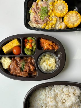Bento or dosirak box filled with rice, assorted side dishes, vegetables, and protein like meat or fish, all neatly arranged to create a balanced, colorful, and visually appealing meal