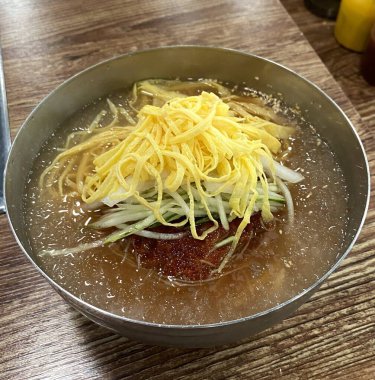 Soğukta çiğnenmiş karabuğday erişteli otantik Pyongyang naengmyeonu taze ve lezzetli bir tat sunuyor. Geleneksel Kore mutfak menüleri ve yaz yemekleri için mükemmel..