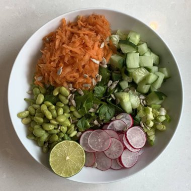 Taze salata taze yapraklı sebzeler, dilimlenmiş sebzeler ve rengarenk malzemelerin karışımı sağlıklı, canlı ve ferahlatıcı bir tat yaratmak için bir araya getirilmiş.