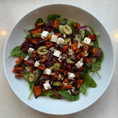 Taze salata taze yapraklı sebzeler, dilimlenmiş sebzeler ve rengarenk malzemelerin karışımı sağlıklı, canlı ve ferahlatıcı bir tat yaratmak için bir araya getirilmiş.