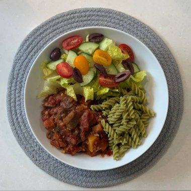 Taze salata taze yapraklı sebzeler, dilimlenmiş sebzeler ve rengarenk malzemelerin karışımı sağlıklı, canlı ve ferahlatıcı bir tat yaratmak için bir araya getirilmiş.