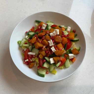 Taze salata taze yapraklı sebzeler, dilimlenmiş sebzeler ve rengarenk malzemelerin karışımı sağlıklı, canlı ve ferahlatıcı bir tat yaratmak için bir araya getirilmiş.