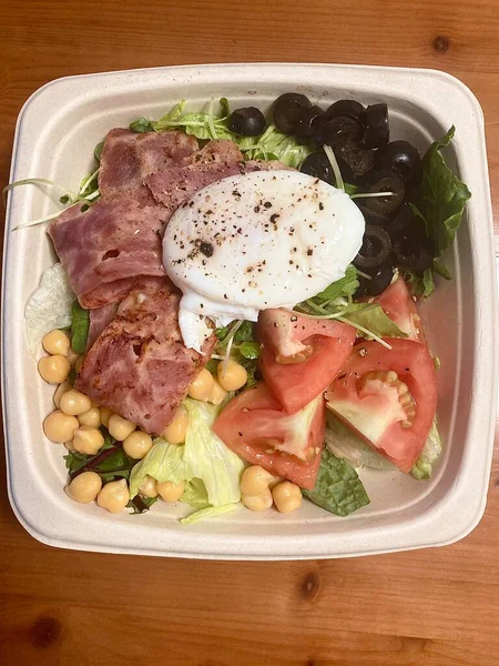 Taze salata taze yapraklı sebzeler, dilimlenmiş sebzeler ve rengarenk malzemelerin karışımı sağlıklı, canlı ve ferahlatıcı bir tat yaratmak için bir araya getirilmiş.