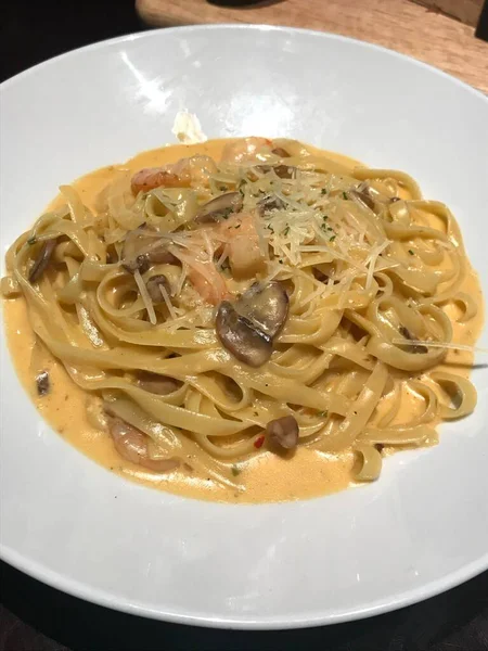 Bir tabak spagetti makarnası, mükemmel pişirilmiş ve üzerine bol marinara sosu ve taze otlar konmuş. Yemek fotoğrafçılığı ve menüler için ideal, İtalyan mutfağının kalbini lezzetli bir şekilde yakalamak..