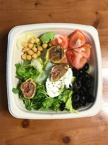 Taze salata taze yapraklı sebzeler, dilimlenmiş sebzeler ve rengarenk malzemelerin karışımı sağlıklı, canlı ve ferahlatıcı bir tat yaratmak için bir araya getirilmiş.