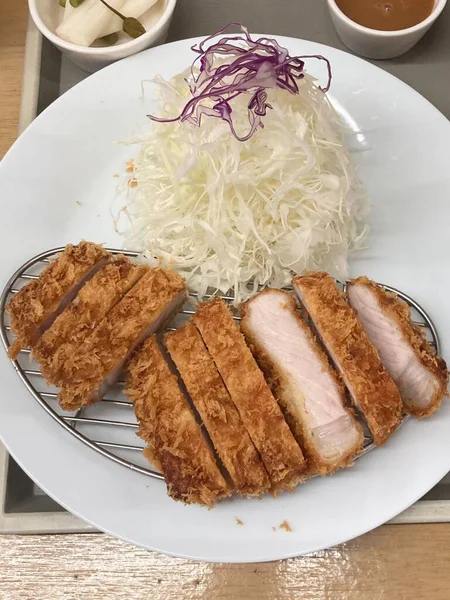 Çıtır tonkatsu, Japon usulü kızarmış domuz pirzolası dilimlenmiş lahana ve tuzlu sosla servis edilir. Lezzetli bir kıtır kıtır doku ve sulu et dengesi.