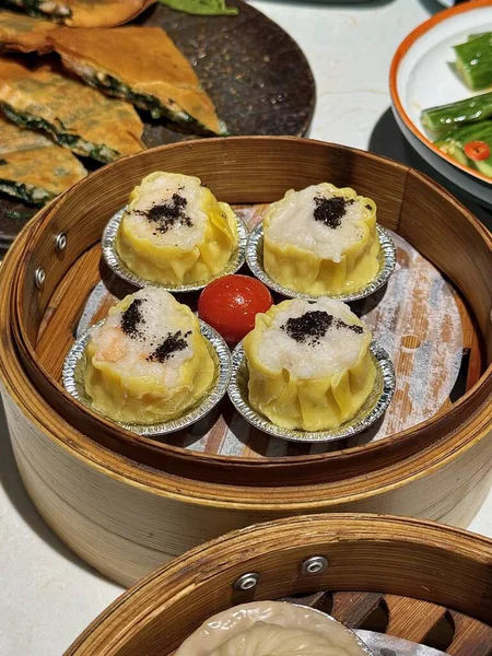 Soslu Shumai karidesi, buğulanmış karides köftesi Dim Sum veya Dim Sum, ahşap masada sebze, kahvaltıda Çin Dimsum yemeği, geleneksel Çin yemeği..