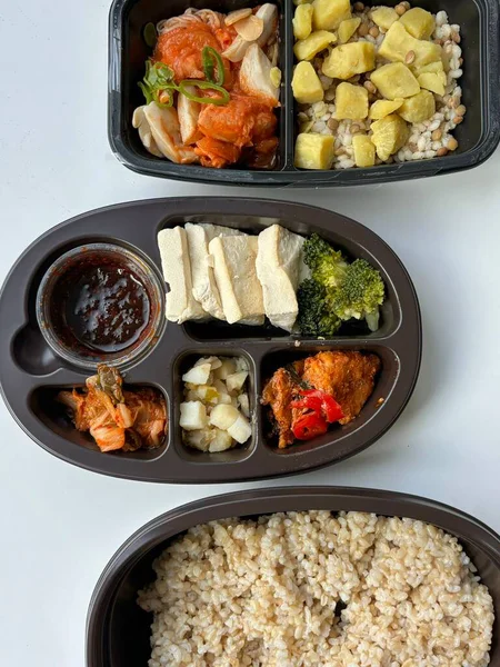 Bento or dosirak box filled with rice, assorted side dishes, vegetables, and protein like meat or fish, all neatly arranged to create a balanced, colorful, and visually appealing meal