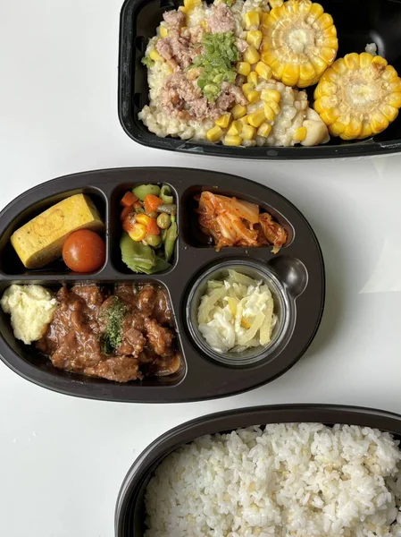 Bento or dosirak box filled with rice, assorted side dishes, vegetables, and protein like meat or fish, all neatly arranged to create a balanced, colorful, and visually appealing meal