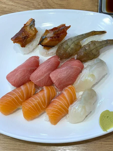 Çeşitli malzemeler ve canlı renklerle sanatsal olarak düzenlenmiş taze suşi çeşitleri. Bu geleneksel Japon yemeği bir deneyim için sirkeli pirinç, deniz ürünleri ve sebzeleri birleştirir..