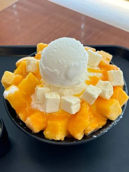 Tüylü buzlu mango bingsu, tatlı mango parçaları ve yoğun sütlü krema. Sıcak günler için mükemmel bir Kore tatlısı, lezzetli meyveli ve kremalı tatlar dengesi sunuyor.!