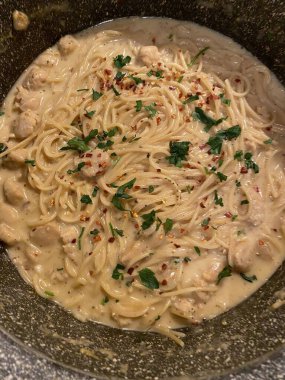 Lezzetli beyaz bir sosla kaplanmış kremalı ve zengin spagetti rahatlatıcı ve tatmin edici bir yemek için mükemmel bir lezzet sunuyor..