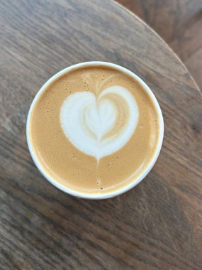 Çok güzel işlenmiş bir latte, kremalı köpüklü sanat eseri ve üstüne de espresso. Kahveyle ilgili projeler için mükemmel. Bu görüntü, klasik bir kafe deneyiminin sıcaklığını ve davetkar doğasını yansıtıyor..