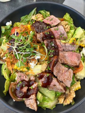 Taze salata taze yapraklı sebzeler, dilimlenmiş sebzeler ve rengarenk malzemelerin karışımı sağlıklı, canlı ve ferahlatıcı bir tat yaratmak için bir araya getirilmiş.