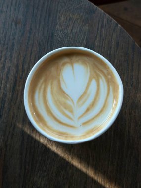 Çok güzel işlenmiş bir latte, kremalı köpüklü sanat eseri ve üstüne de espresso. Kahveyle ilgili projeler için mükemmel. Bu görüntü, klasik bir kafe deneyiminin sıcaklığını ve davetkar doğasını yansıtıyor..