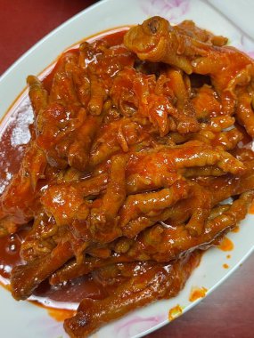 Baharatlı ve çiğnenmiş dakbal (Koreli tavuk ayağı) koyu, ateşli bir jöleyle kaplanmıştır. Yoğun sıcak ve tuzlu derinlikte lezzetli bir sokak yemeği favorisi. Maceracı yiyiciler için mükemmel..