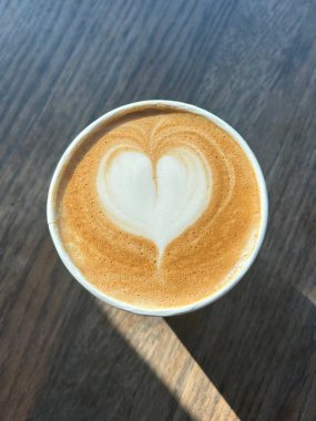 Çok güzel işlenmiş bir latte, kremalı köpüklü sanat eseri ve üstüne de espresso. Kahveyle ilgili projeler için mükemmel. Bu görüntü, klasik bir kafe deneyiminin sıcaklığını ve davetkar doğasını yansıtıyor..