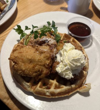 Üstünde bol kremalı vanilyalı dondurma ve çikolata sosu serpiştirilmiş çıtır altın waffle. Klasik, hoşgörülü bir tatlı..