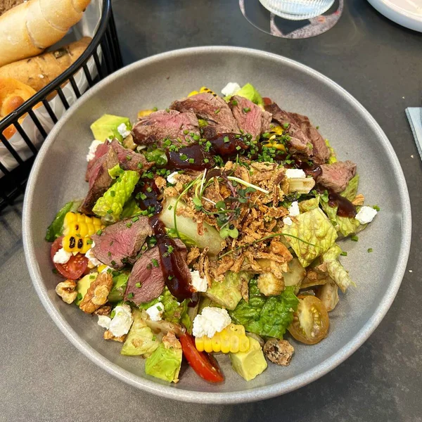 Taze salata taze yapraklı sebzeler, dilimlenmiş sebzeler ve rengarenk malzemelerin karışımı sağlıklı, canlı ve ferahlatıcı bir tat yaratmak için bir araya getirilmiş.